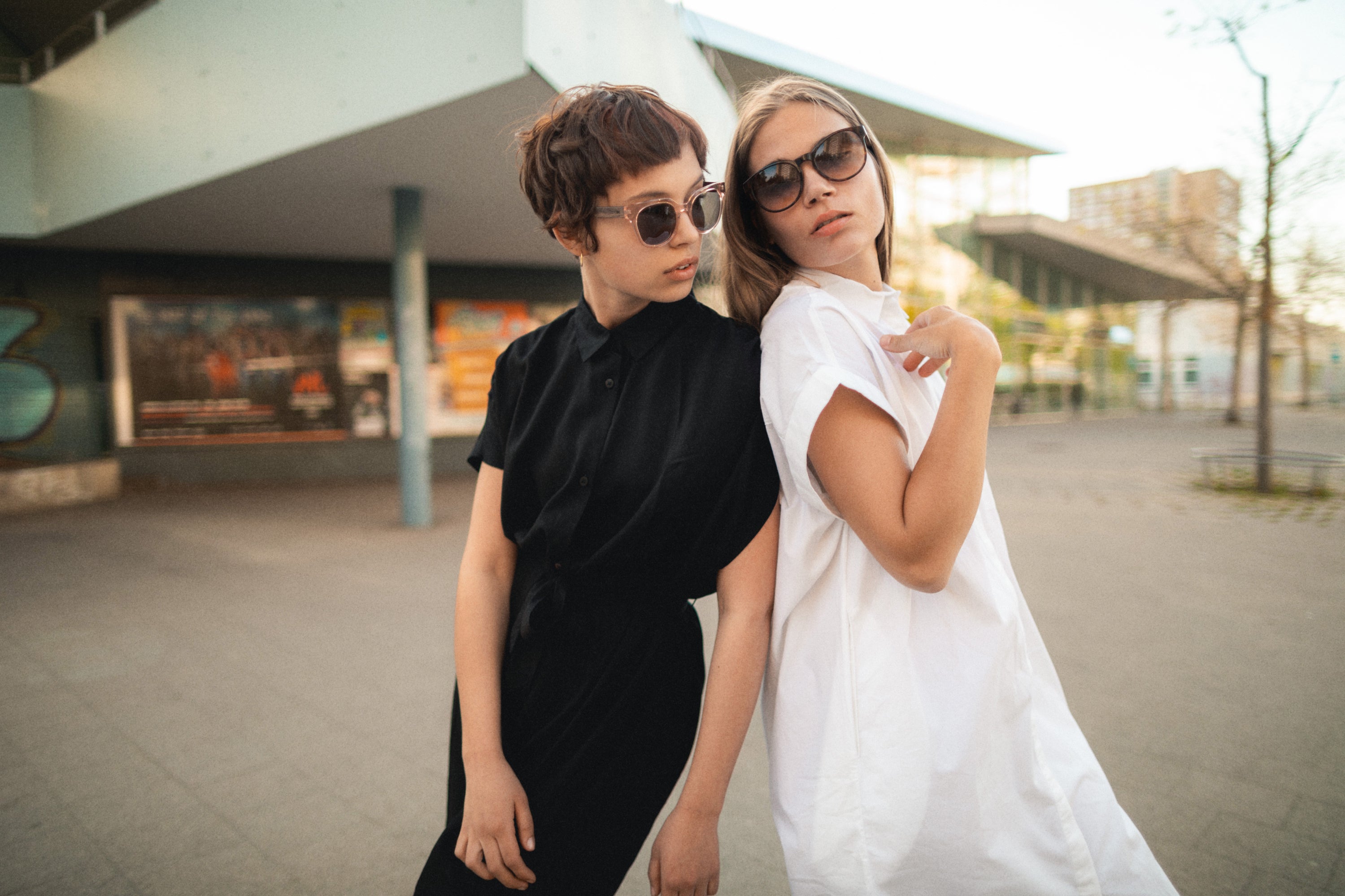 Marlene nachhaltige Holz Sonnenbrille transparenter Rahmen blaue Sonnenbrillengläser Rückentspiegelung Outdoor TAKE A SHOT schwarzes und weißes Blusenkleid